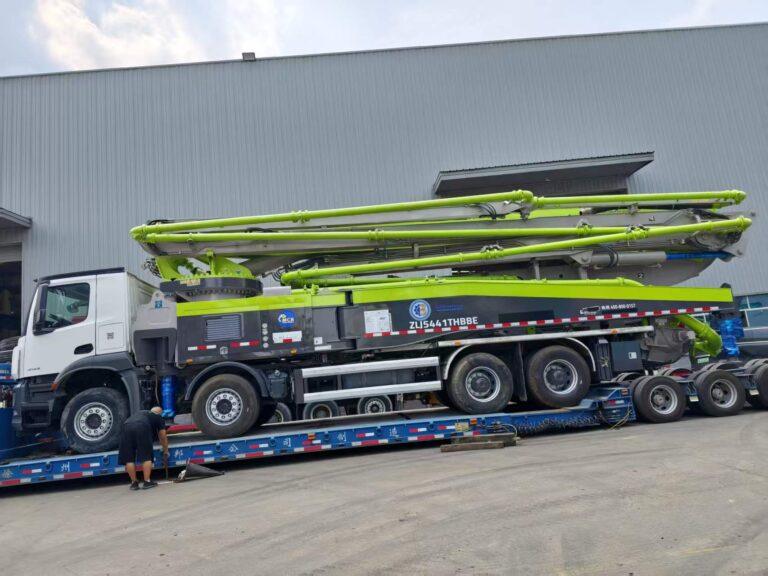 Original Mechabro field photo of a 2020 Zoomlion 56m used concrete pump truck on a low-bed trailer for a customer dispatch to Africa
