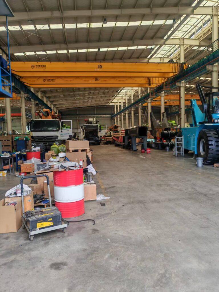 Original Mechabro field photo of the workshop aisle, trucks and equipment components in Changsha